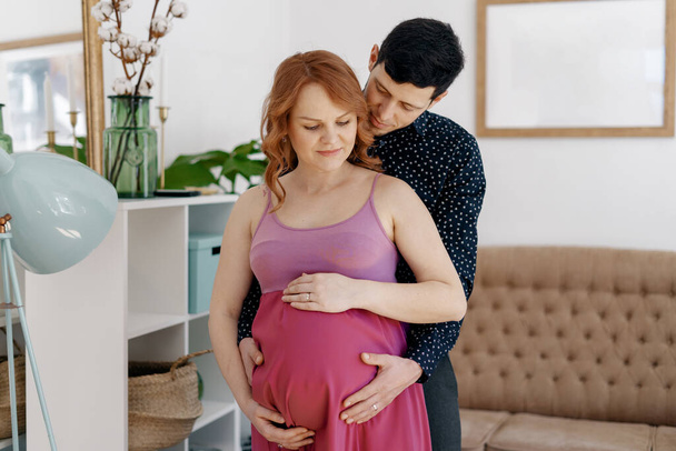 Νεαρό ελκυστικό ζευγάρι έγκυος μητέρα και ευτυχισμένος πατέρας - Φωτογραφία, εικόνα