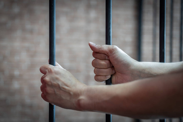 Conceito de escravidão e tráfico de vítimas com mulher prisioneira na prisão segurando bar sendo torturada, punida ou abusada em violação
  - Foto, Imagem