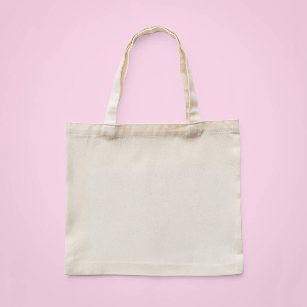 Bolso de mano maqueta de tela de algodón blanco tela eco shopping saco maqueta en blanco plantilla aislada sobre fondo rosa pastel (camino de recorte
) - Foto, imagen
