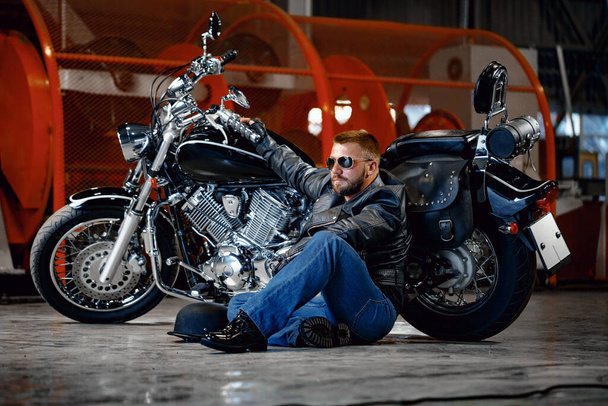 Cool uomo motociclista in occhiali da sole seduto vicino alla sua moto
 - Foto, immagini