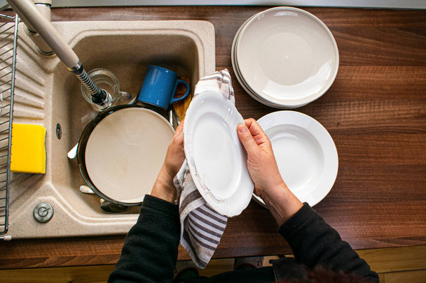 Γυναίκα σκούπισμα πιάτα με βαμβάκι πετσέτα στην κουζίνα - Φωτογραφία, εικόνα