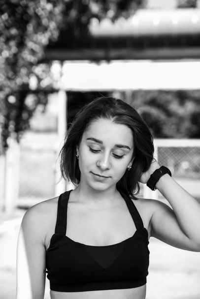 Portrait of attractive sport woman in sportswear posing outdoors at the stadium.Sport and healthy lifestyle.Black and white photo - Zdjęcie, obraz