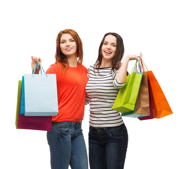iki genç kız alışveriş torbaları ile gülümseyen - Fotoğraf, Görsel