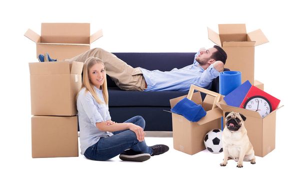 Konzept für einen bewegten Tag - müdes Paar und Kartons mit Sachen auf weißem Hintergrund - Foto, Bild