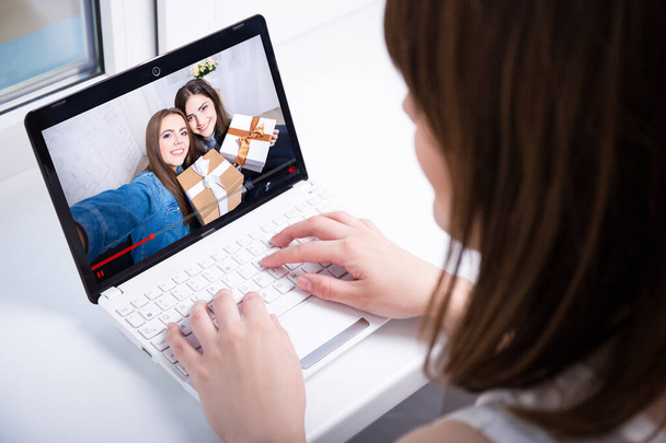 wstecz widok młodej kobiety oglądającej wideo blog na laptopie w domu - Zdjęcie, obraz