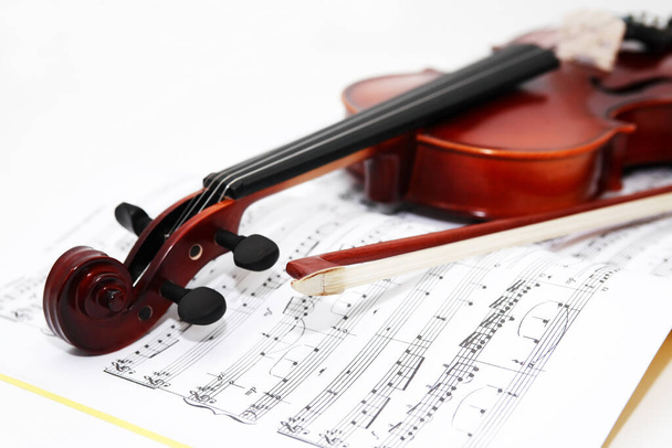 Νίκαια βιολί και τόξο για το βιβλίο μουσικής σε λευκό φόντο - Φωτογραφία, εικόνα