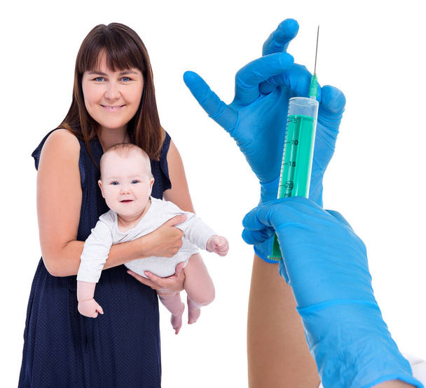 concepto de vacunación - madre joven sosteniendo a la niña y las manos del médico con jeringa aislada sobre fondo blanco
 - Foto, imagen