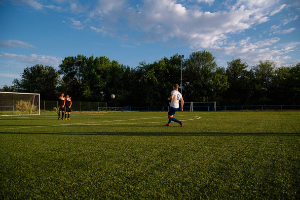 Soccer player kicks the ball.Soccer player takes the free-kick.Football player kicks the ball on the football field.Football sports concept - Zdjęcie, obraz
