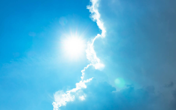 sol brillante en el cielo azul con nubes esponjosas y luz de bengala
 - Foto, Imagen
