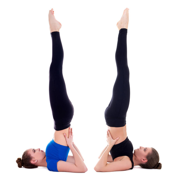 dvě krásné sportovní ženy dělá jóga cvičení izolované na bílém pozadí - Fotografie, Obrázek