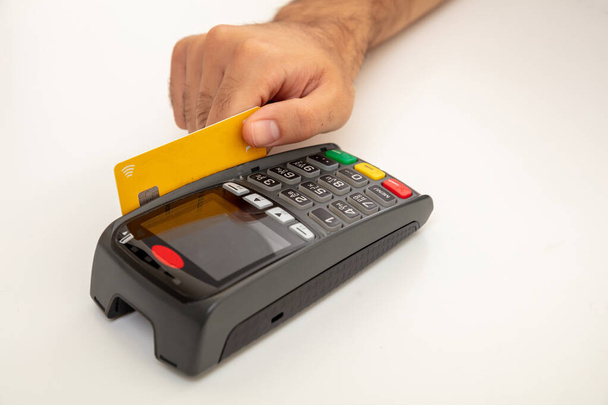 Kézzel lopás egy hitelkártya egy POS terminál elszigetelt fehér háttér, közelkép megtekintése.Terminál pénztárgép készpénz nélküli fizetés. - Fotó, kép