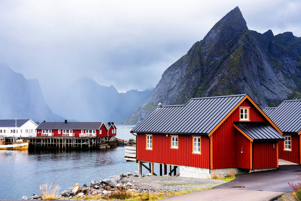 Famous tourist attraction Hamnoy fishing village on Lofoten Islands, Norway with red and yellow rorbu houses. Calm, blurred water - Foto, immagini