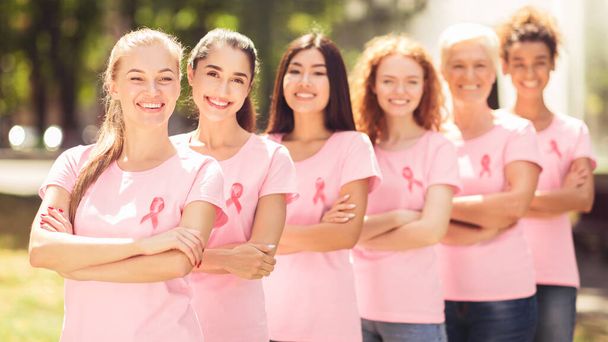 Volontari del cancro al seno in piedi sorridenti alla macchina fotografica nel parco, Panorama - Foto, immagini