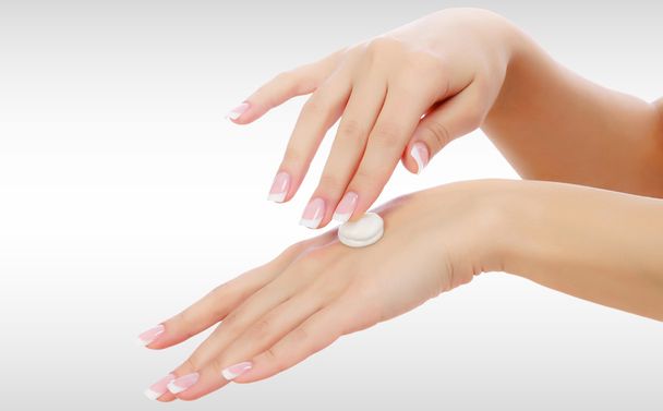 Female hands with a moisturiser on light grey background - Photo, Image