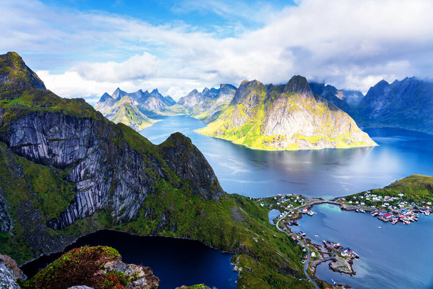 Солнечный воздушный панорамный вид на потрясающие горы и деревню Ринг на Лоффских островах, Норвегия, с хребта Эббингем. Сценическая панорама с радугой и прочными вершинами
. - Фото, изображение