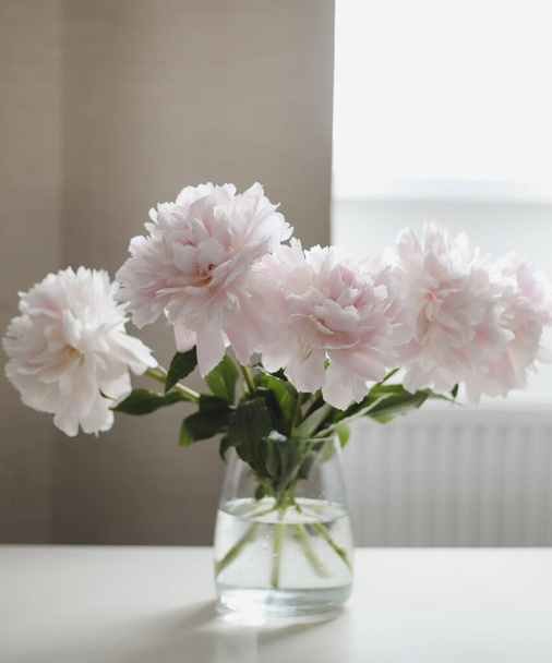 ホームインテリアの花瓶に美しいピンクの牡丹。花の構成。花屋のコンセプト。美しい新鮮なカット花束。コピースペース - 写真・画像