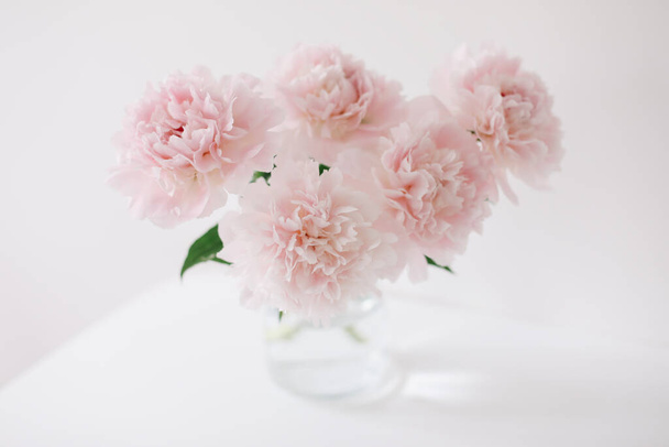 Beautiful pink peonies in a vase at home interior. Flower composition. Floral shop concept. Beautiful fresh cut bouquet. copyspace - Foto, imagen