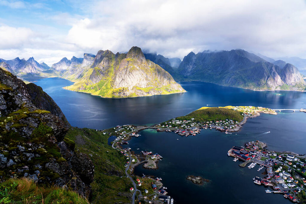 Солнечный воздушный панорамный вид на потрясающие горы и деревню Ринг на Лоффских островах, Норвегия, с хребта Эббингем. Сценическая панорама с радугой и прочными вершинами
. - Фото, изображение