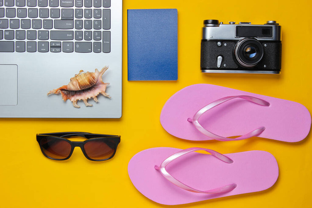Yaz tatili. Yaz tatili gevşemesi. Laptop ve seyahat aksesuarları sarı arka planda. Stüdyo kısa. Plaj objesi. Üst Manzara. Düz yatıyordu - Fotoğraf, Görsel