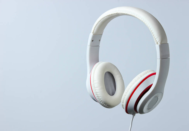 White classic wired headphones isolated on a gray background. Retro style. Minimalistic music concept. - Photo, Image