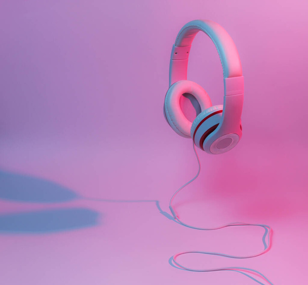 Klasszikus vezetékes fejhallgató lejtős kék rózsaszín neonfénnyel. Retro stílus. Retro hullám. 80-as évek. Minimalista zenei koncepció. - Fotó, kép