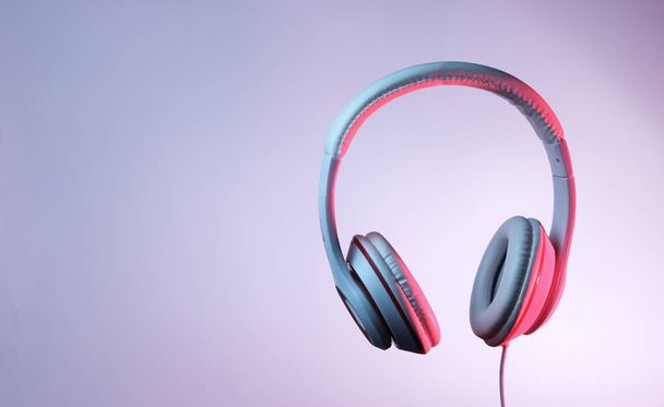 Classic wired headphones with gradient blue pink neon light. Retro style.Retro wave. 80s. Minimalistic music concept. - Photo, Image