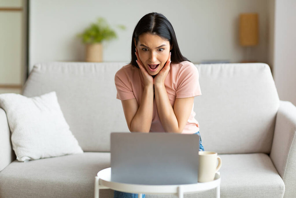 Mulher descontente no laptop gritando com problemas sentado em casa
 - Foto, Imagem