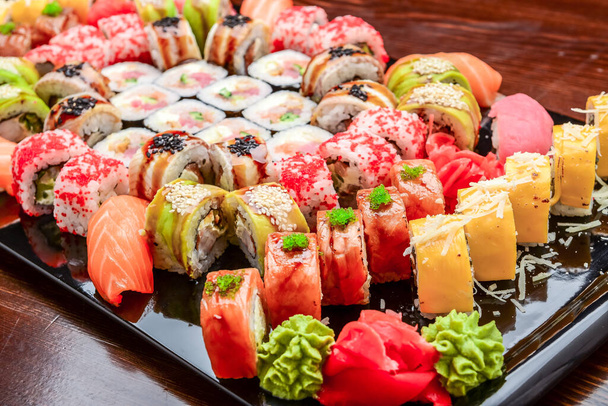 Zestaw sushi - Maki Sushi alaskan roll, yin yang roll i Nigiri Sushi tuńczyk, łosoś, węgorz. Na drewnianym tle - Zdjęcie, obraz