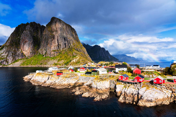 Famous tourist attraction Hamnoy fishing village on Lofoten Islands, Norway with red and yellow rorbu houses. Calm, blurred water - Foto, Imagen