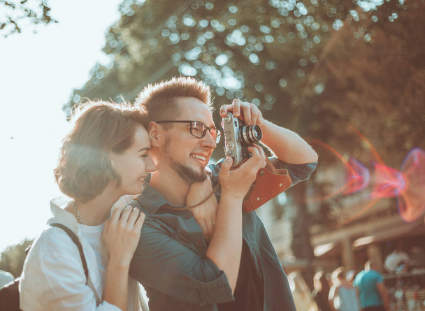 Junges verliebtes Hipster-Paar spaziert mit Retro-Kamera durch eine Straße der Stadt - Foto, Bild