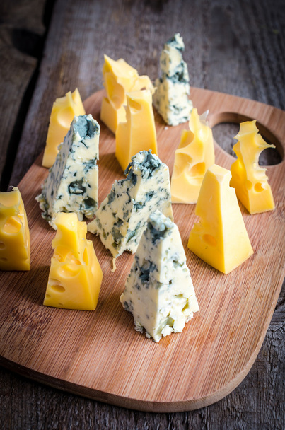 stukken van emmental en blauwe kaas - Foto, afbeelding