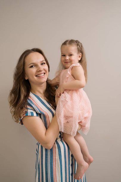 Ritratto madre e figlia su sfondo beige - Foto, immagini