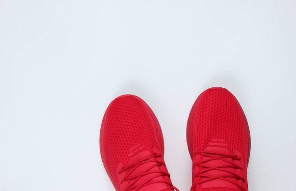 Sapatos de esportes vermelhos masculinos elegantes para correr em um fundo branco. Vista superior
 - Foto, Imagem