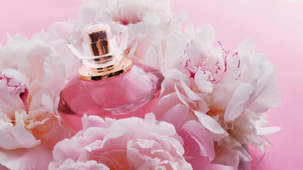 Pink perfume bottle with peony flowers, chic fragrance scent as luxury cosmetic, fashion and beauty product background - Footage, Video