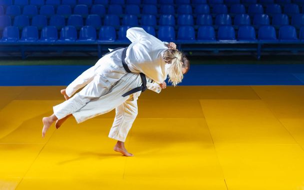 Sztuka walki. Oszczędzam Portnerów. Sport mężczyzna i kobieta w białym kimono pociąg judo rzuca i przechwytuje w hali sportowej - Zdjęcie, obraz