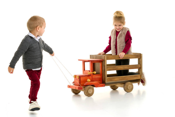 Brother and sister are playing with a toy car. - Foto, imagen