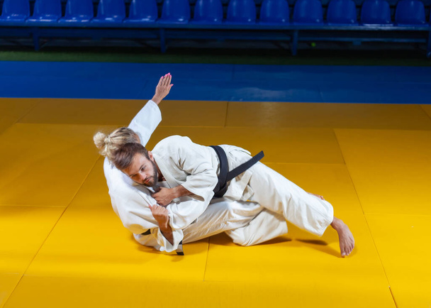 Sztuka walki. Oszczędzam Portnerów. Sport mężczyzna i kobieta w białym kimono pociąg judo rzuca i przechwytuje w hali sportowej - Zdjęcie, obraz