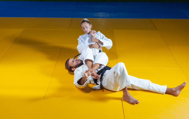 Harcművészet. Megkímélő Portnerek. Sport férfi és nő fehér kimonó vonat judo dob és elfog a sportcsarnokban - Fotó, kép