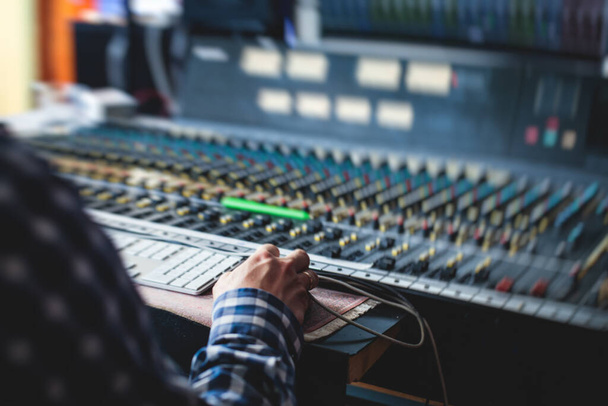 Sound editor engineer working at studio with mixing panel, mixing music and sound, stage sound mixer, boutique recording studio, working during concert performance recording, broadcasting studio - Photo, image
