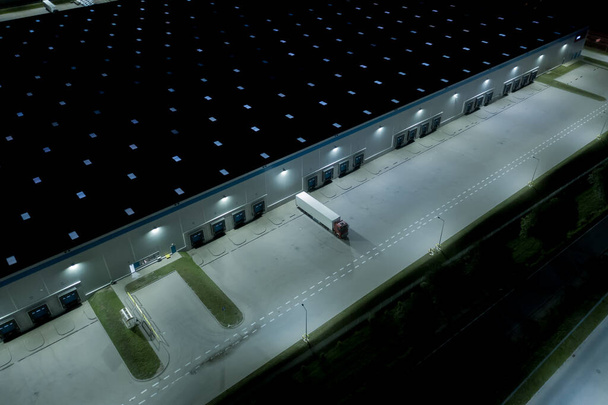 Ночной Воздушный беспилотник на распределительном центре. Логистическая и транспортная концепция
 - Фото, изображение