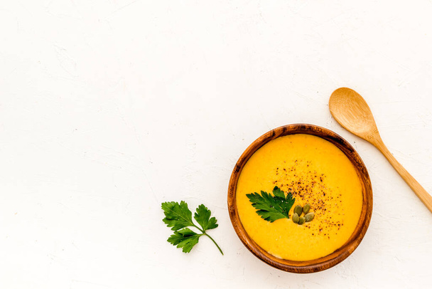 Pumpkin cream soup on white background top-down. Healthy vegetarian food. Copy space - Foto, Imagem