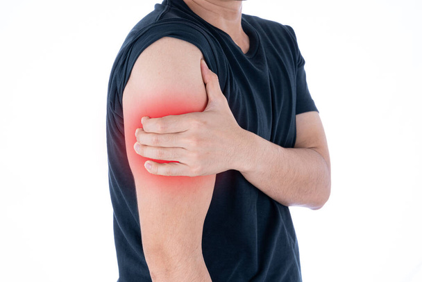 A man feeling exhausted and suffering from arm pain and injury on isolated white background with red spot. Health care and medical concept. - Фото, зображення