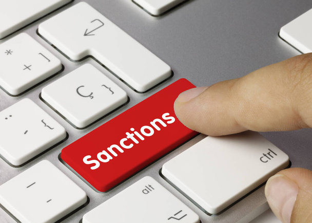 Sanctions Written on Red Key of Metallic Keyboard. Finger pressing key. - Photo, Image