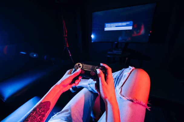 Közelről női kéz tartja gamepad és videojáték - Fotó, kép