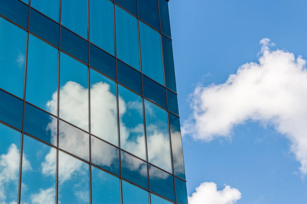 Clouds reflected in windows of a modern office building - Foto, imagen