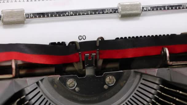 scrivendo sulla macchina da scrivere vintage il testo CORONAVIRUS sul foglio bianco - Filmati, video