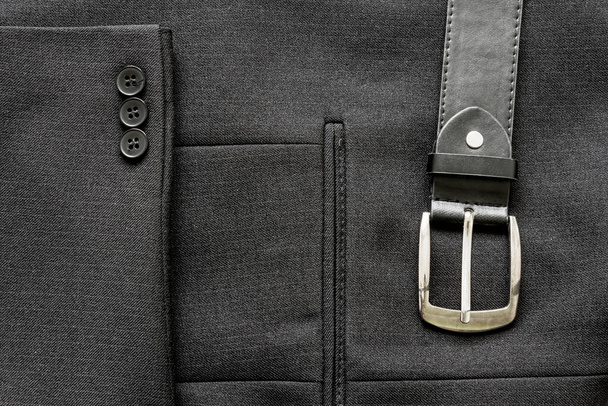 Close-up van een paar knopen op een zakelijke pak jas en een leren riem - Foto, afbeelding