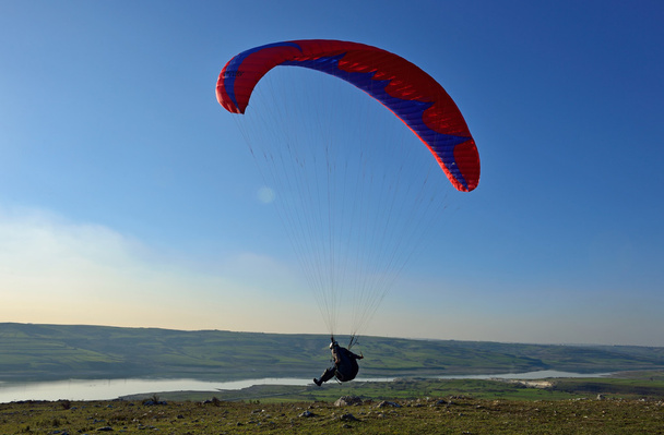 Paraglider taking off van een berg - Foto, afbeelding