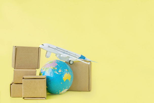 Airplane and stack of cardboard boxes. concept of air cargo and parcels, airmail. Fast delivery of goods and products. Cargo aircraft. Logistics, connection to hard-to-reach places. Banner, copy space. - Foto, afbeelding