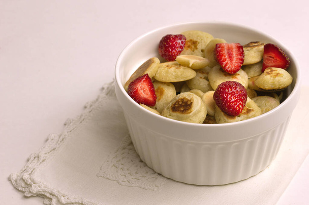 Pfannkuchen mit Erdbeeren, gesundes Frühstück, Pfannkuchenbrei auf grauem Hintergrund - Foto, Bild